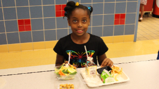 student in cafeteria with meal