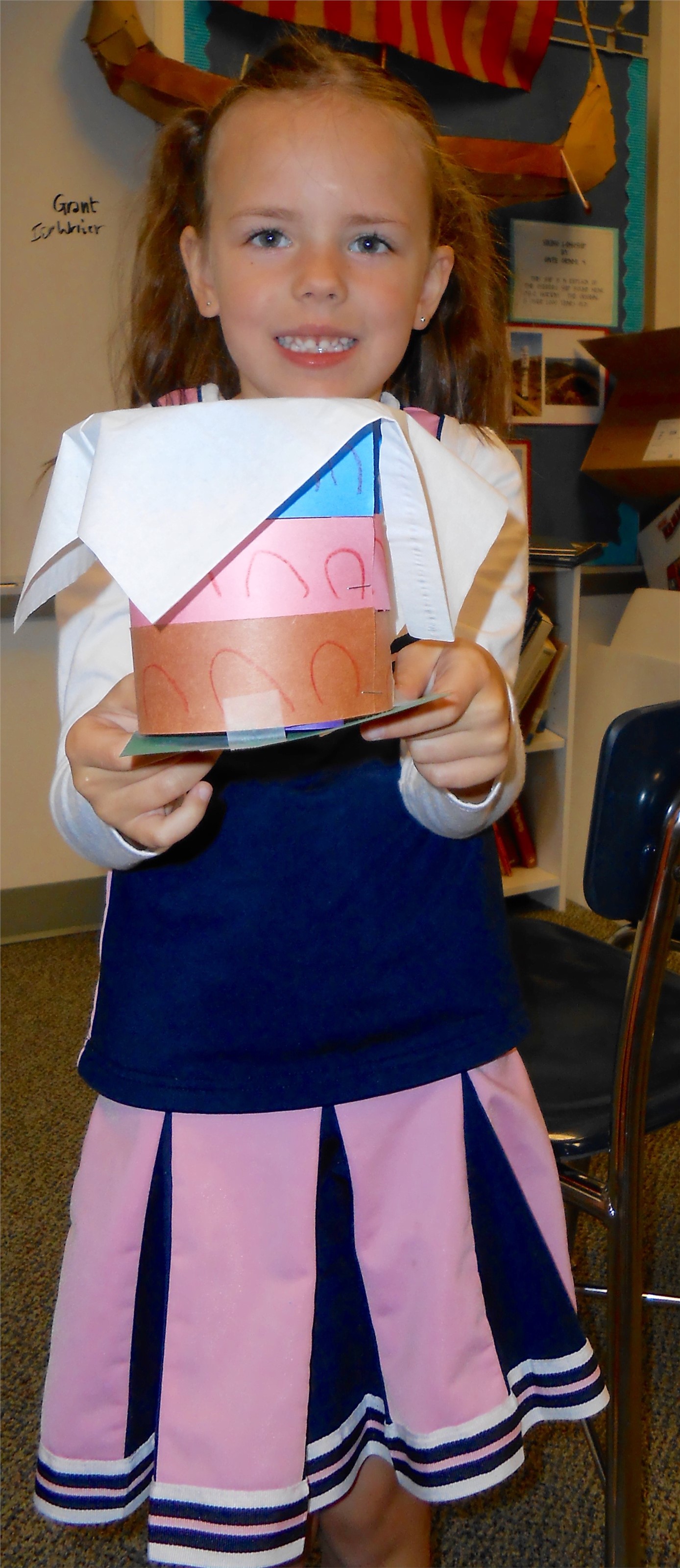 Kindergartener holds model of ancient building.
