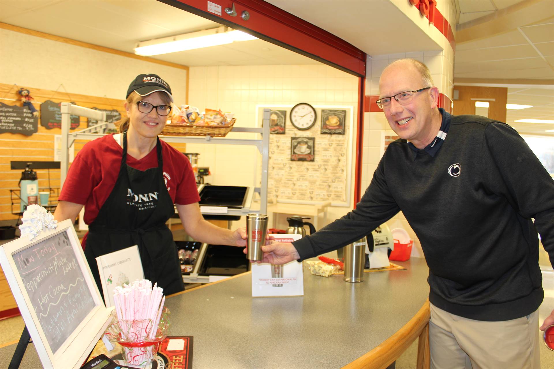 High school teacher Jeffrey Allshouse refills his reusable "We Are North Hills" coffee tumbler. 