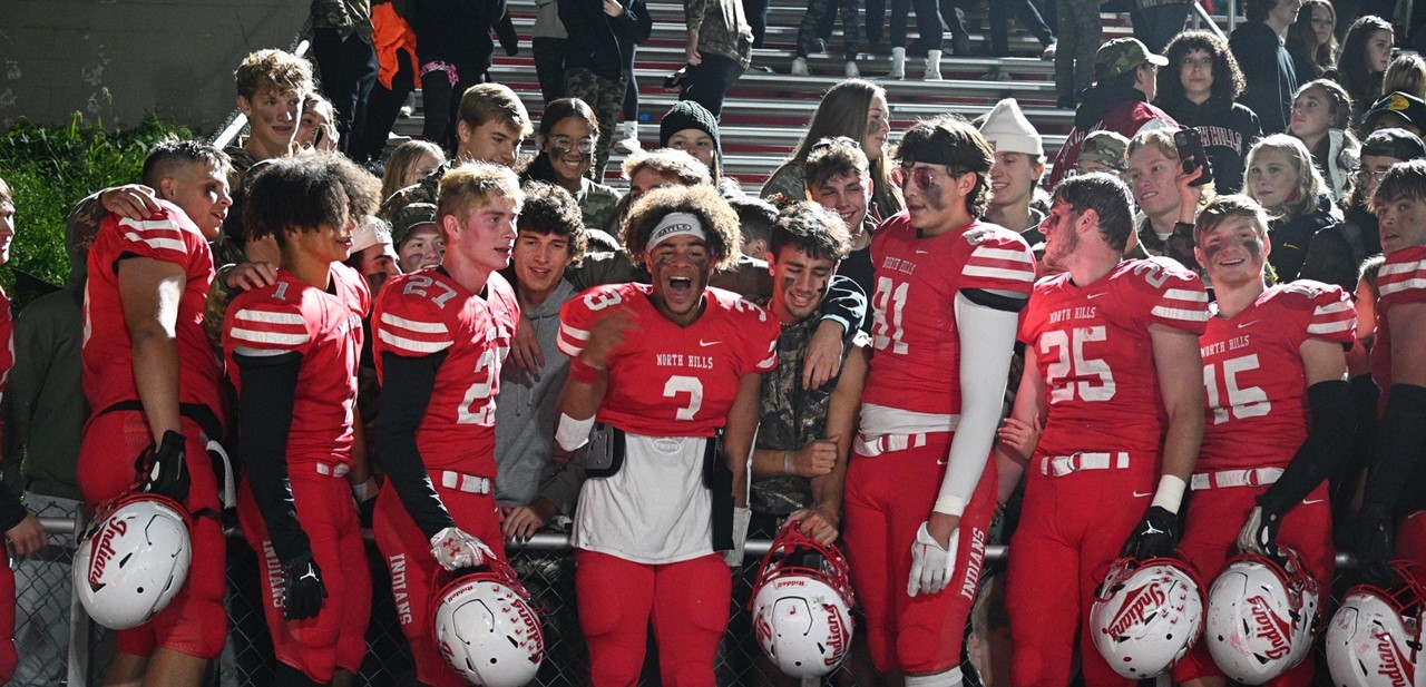 football players cheering with students