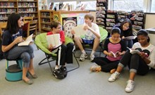 Photo of Middle School students reading books in library